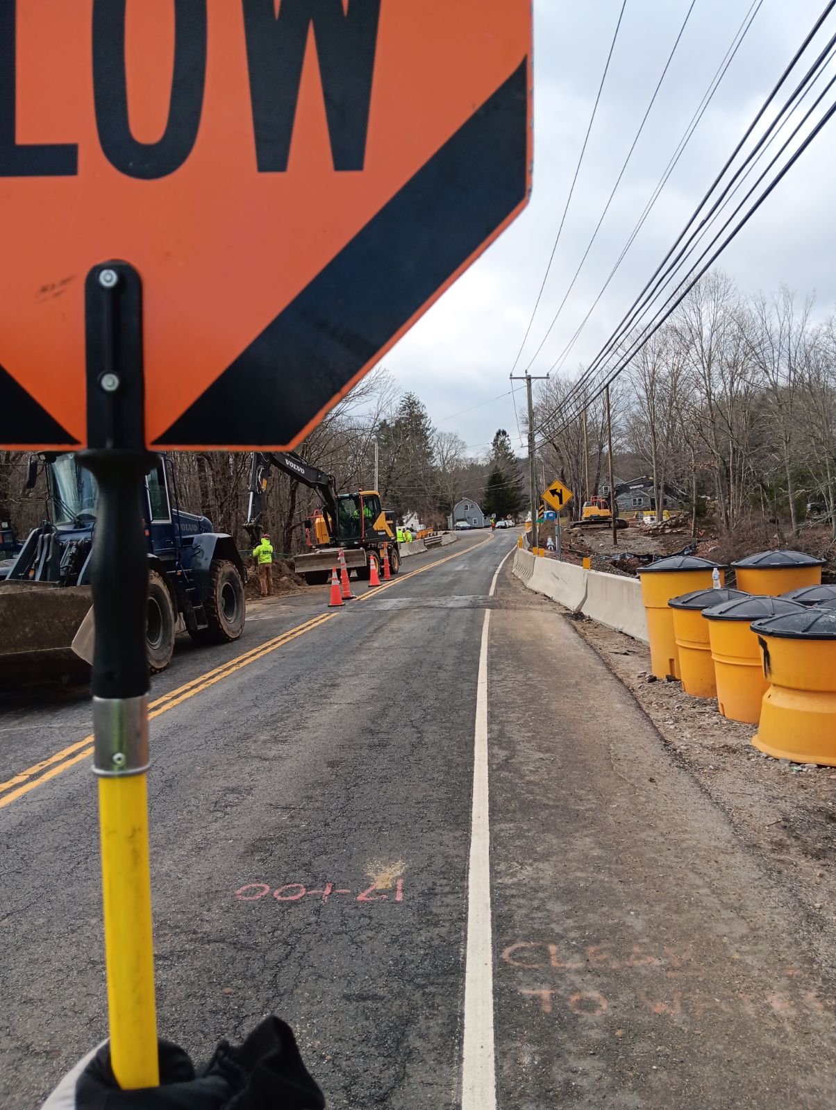 A flagging paddle beside an active roadway construction zone.